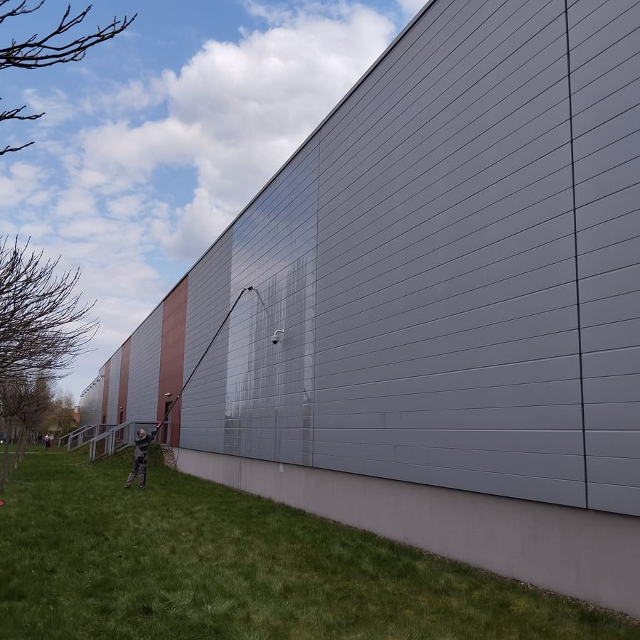 Mycie elewacji hali komercyjnej tyczką teleskopową