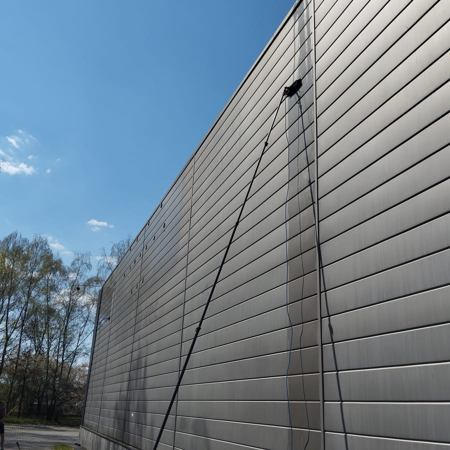 Czysta elewacja hali przy zalesionym terenie