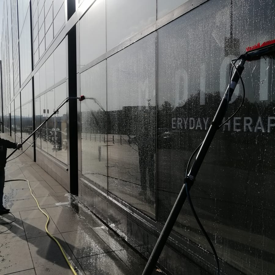 Mycie czarnej szklanej fasady tyczką ciśnieniową